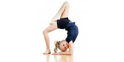 A young girl is doing a handstand pose.