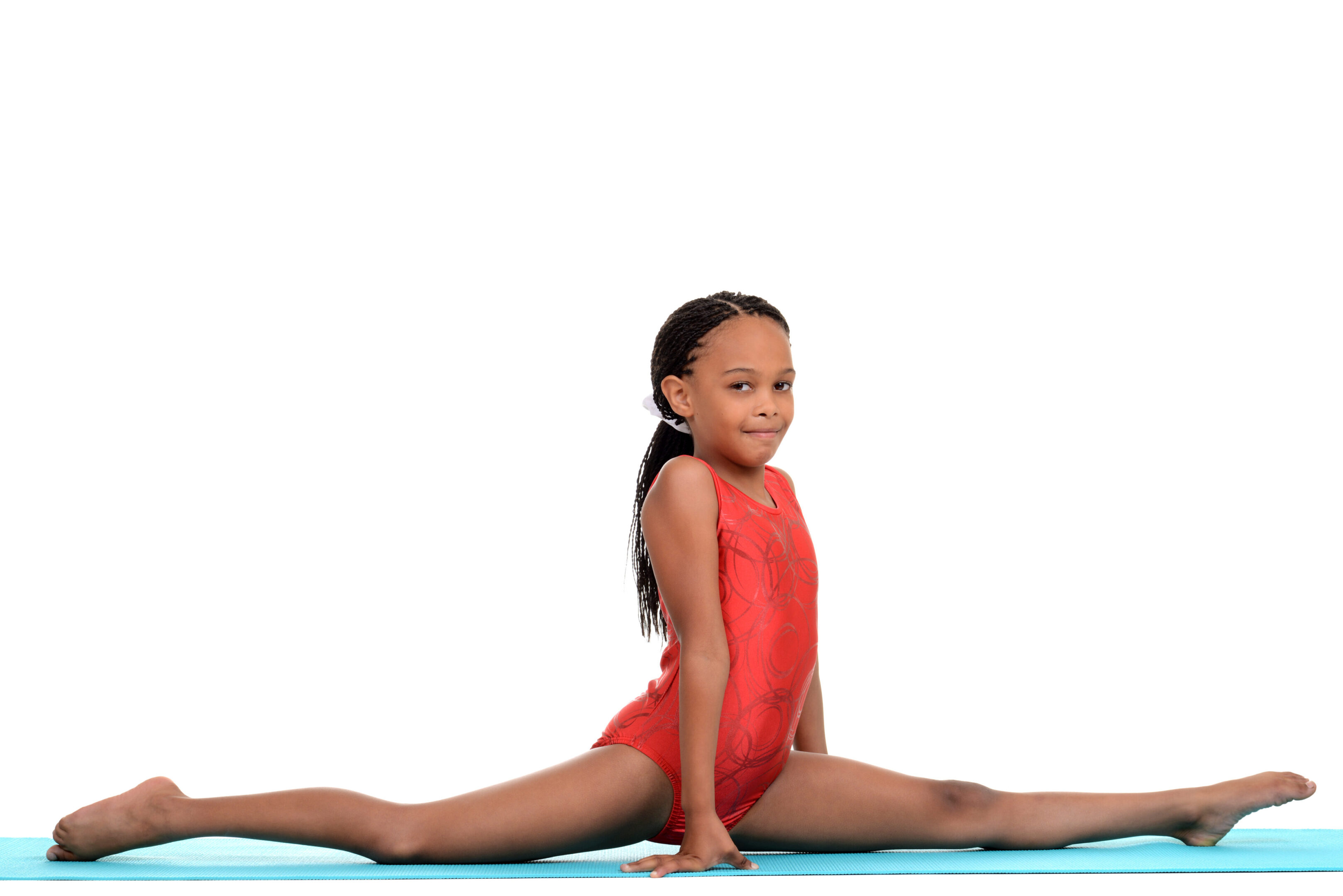 A young girl in red is doing a split.